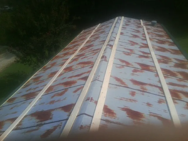 Rusted metal roof panels with new wood purlins before replacement — Storm Damage Roof Repair in Leo by Roofing Brothers